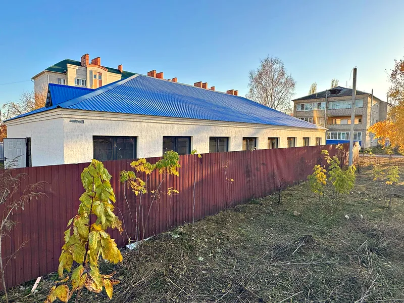 Здание с дороги: белые стены, синяя кровля